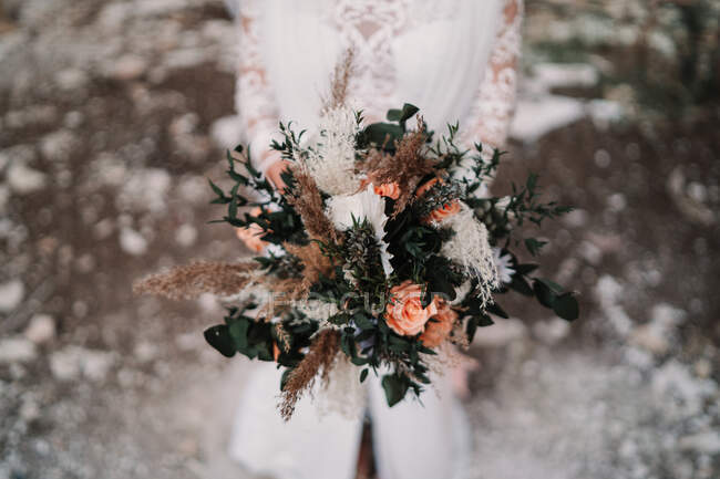 Ernte anonyme weibliche Braut mit zarten Blume blühenden Strauß trägt elegante weiße Kleid — Stockfoto