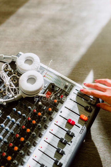 Обрізати руку жінки, використовуючи еквалайзер в музичній студії на розмитому фоні — стокове фото