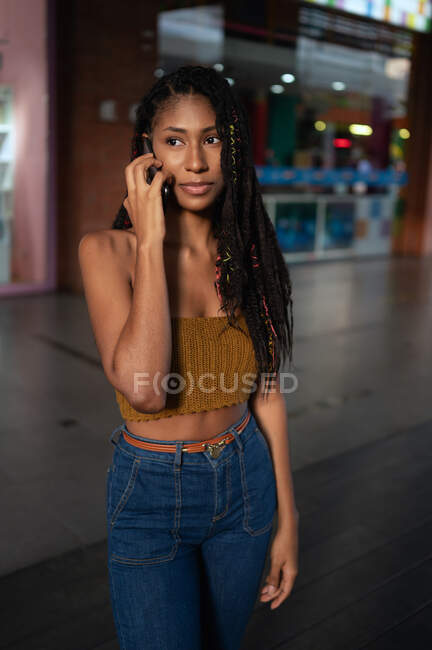 Portrait of attractive young afro latin woman speaking on a smartphone in a commercial mall, Colombia — Stock Photo