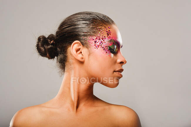 Portrait of brunette woman with ponytail and makeup eyes looking down — Stock Photo
