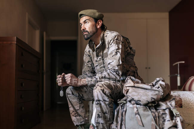 Bajo ángulo de hombre serio en uniforme militar preparándose para servir en el ejército - foto de stock