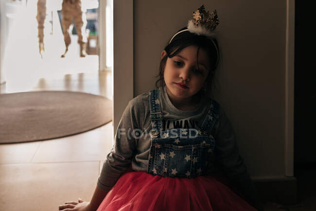 Petite fille désespérée portant une robe de fête et une couronne attendant papa venant du service militaire — Photo de stock