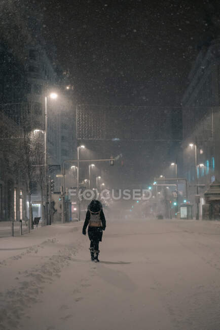 Visão traseira do homem anônimo em outerwear andando na estrada no inverno nevado em Madrid Espanha — Fotografia de Stock