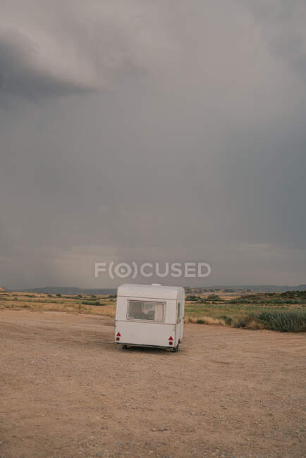 Area sosta camper su terreno sabbioso contro roccia cielo nuvoloso di giorno — Foto stock
