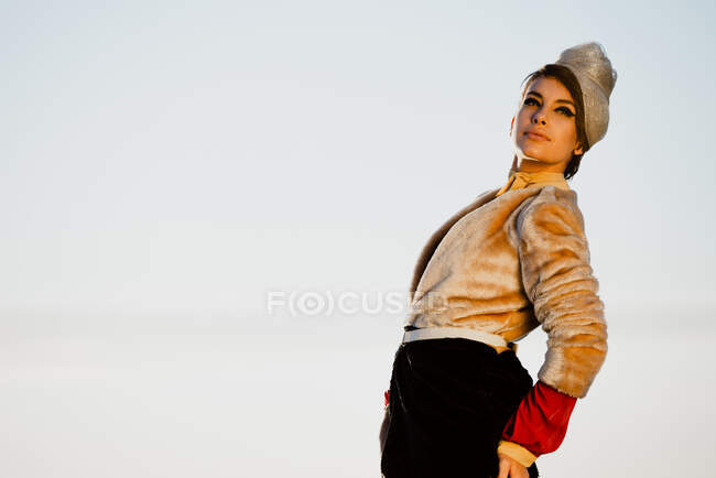 Side view of young dreamy female in retro clothes leaning back while looking away in daylight — Stock Photo