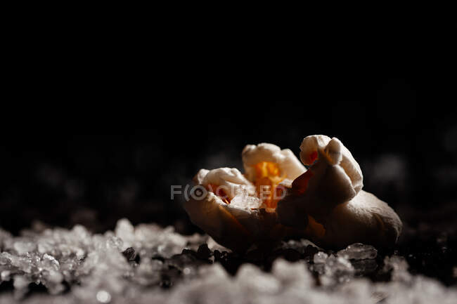 Gros plan d'un délicieux pop-corn sur une couche de sel — Photo de stock