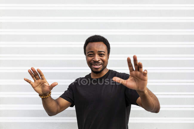 Content African American man in black t shirt standing looking at camera on light background — Stock Photo