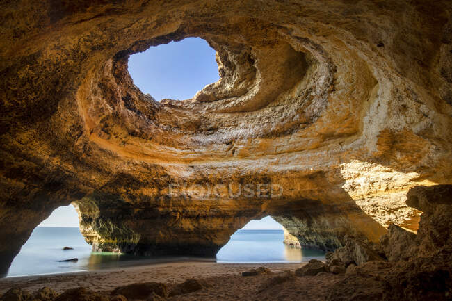 Vista panorâmica da Caverna de Benagil com buracos na costa contra um oceano sem fim no Algarve Portugal — Fotografia de Stock