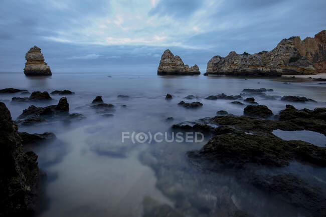 Vista pitoresca de formações rochosas no litoral oceânico sob o pôr-do-sol na Praia do Camilo, Algarve Portugal — Fotografia de Stock