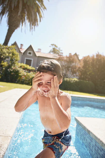 Fröhlicher, hemdloser kleiner Junge, der in den Sommerferien auf dem Land ins Pool-Wasser springt — Stockfoto