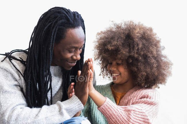 Alegre pai afro-americano acariciando com cabelos cacheados sorridente filha enquanto tendo tempo agradável juntos — Fotografia de Stock