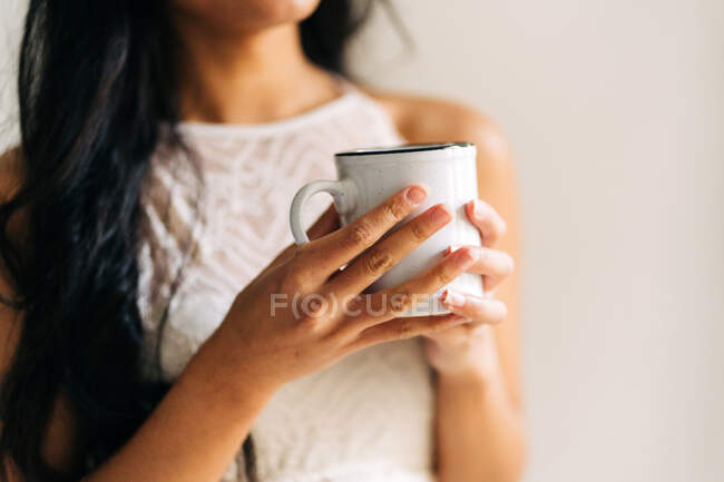 Close-up de uma mulher irreconhecível segurando uma xícara de café — Fotografia de Stock