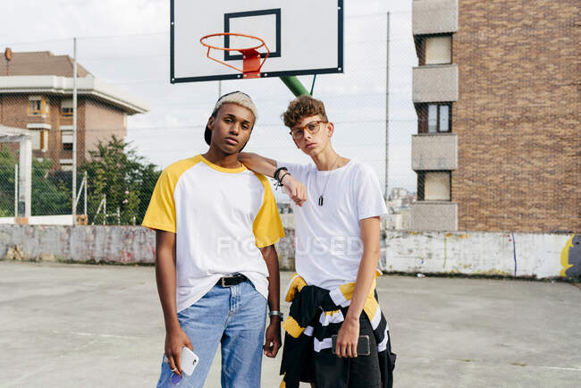 Двоє хлопчиків-підлітків стоять і дивляться на камеру на міському кошику — стокове фото