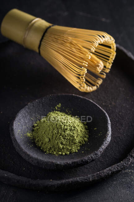 From above of dried tea leaves in heap on plate with chasen for tea ceremony — Stock Photo