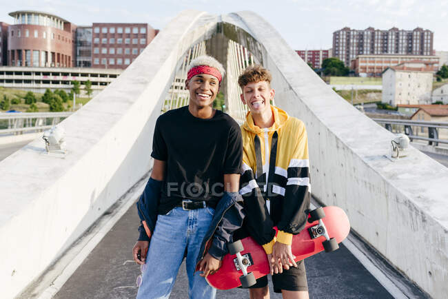 Due bei ragazzi adolescenti con lo skateboard in piedi sul ponte — Foto stock
