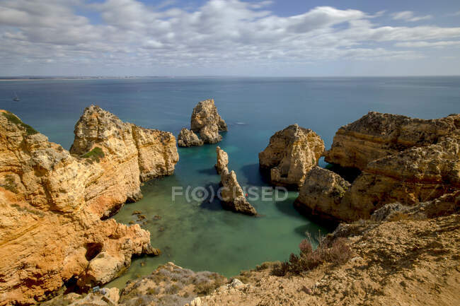 Vista espetacular da Ponta da Piedade em mar sem fim com linha de horizonte sob céu azul com nuvens no Algarve Portugal — Fotografia de Stock