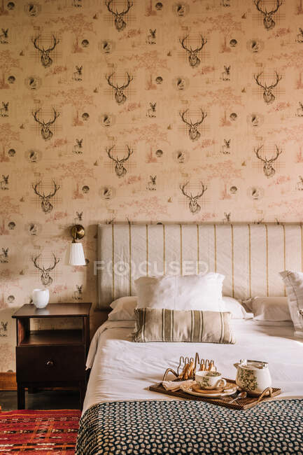 Interior of stylish bedroom with comfortable bed covered with coverlet — Stock Photo