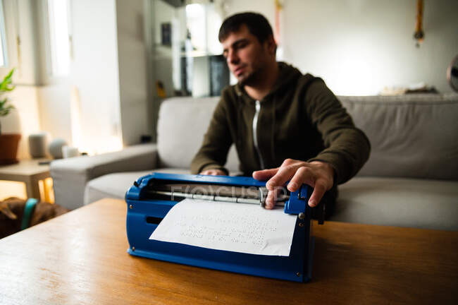 Visually impaired male typing on typewriter with tactile writing system at home — Stock Photo