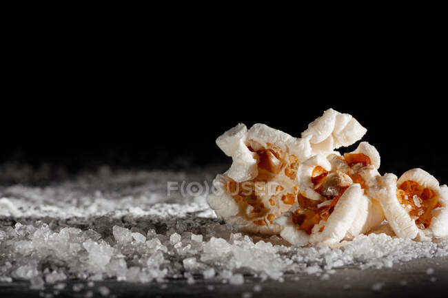 Closeup of a delicious popcorn on a layer of salt — Stock Photo