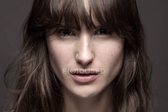 Серьёзная женщина с макияжем и веснушками на носу — стоковое фото