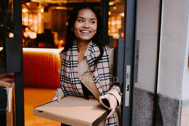 Asian woman picking up take out food in a restaurant — Stock Photo