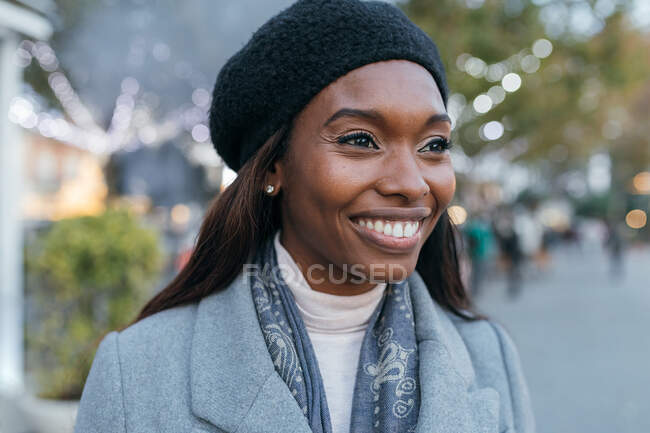 Close-up afro-americano feminino de pé na rua outerwear e com fones de ouvido — Fotografia de Stock