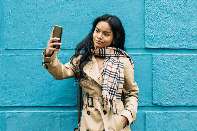 Cheveux longs brune asiatique femme en utilisant téléphone mobile dans la rue — Photo de stock
