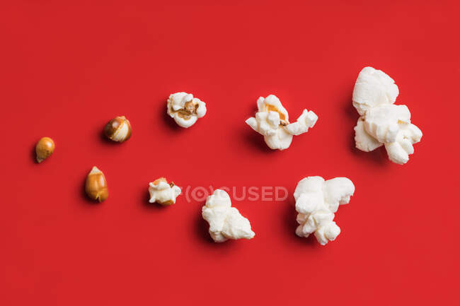 Primer plano de algunas palomitas de maíz sobre un fondo rojo - foto de stock