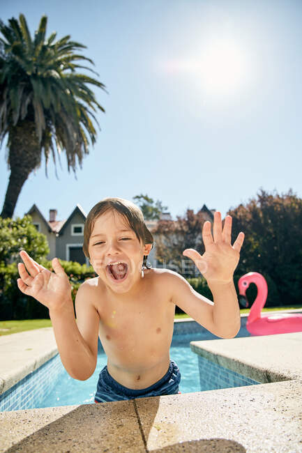 Criança sorridente bonito inclinado na borda da piscina, enquanto descansa após a natação no dia ensolarado — Fotografia de Stock