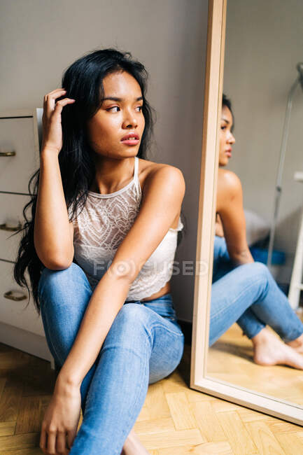 Morena de cabelos compridos Mulher asiática olhando no espelho — Fotografia de Stock