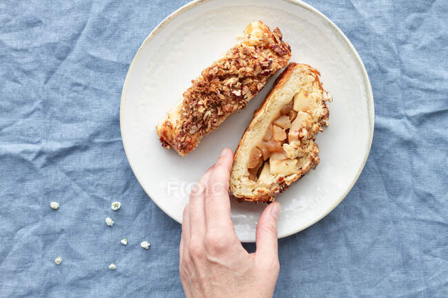 From above of crop anonymous person with pieces of delicious apple pastry with crunchy pecan nuts on top — Stock Photo