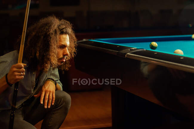 Сосредоточенный бородатый мужчина играет в бильярдный бассейн — стоковое фото