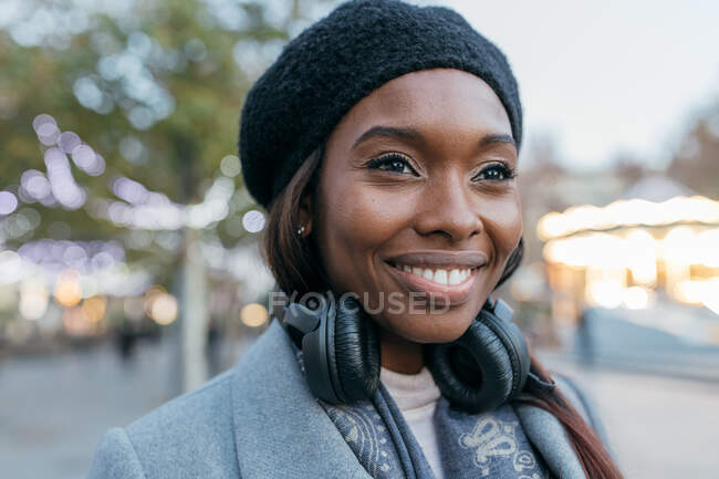 Primer plano mujer afroamericana de pie en la calle de ropa interior y con auriculares - foto de stock