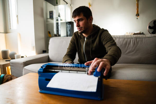 Mecanografía masculina con discapacidad visual en la máquina de escribir con sistema de escritura táctil en casa - foto de stock