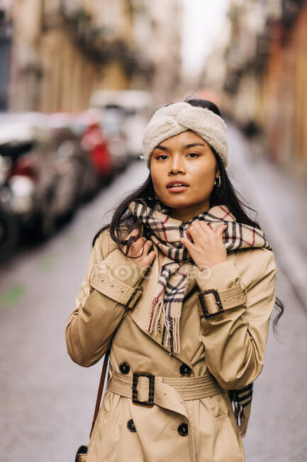 Retrato de una mujer asiática con turbante marrón posando en la calle - foto de stock