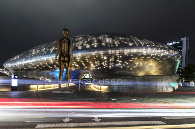 Южная Корея - 28 июня 2018 года: Светящаяся Dongdaemun Design Plaza с бронзовыми статуэтками достопримечательностей в центральном районе Сеула и популярных туристических направлений — стоковое фото