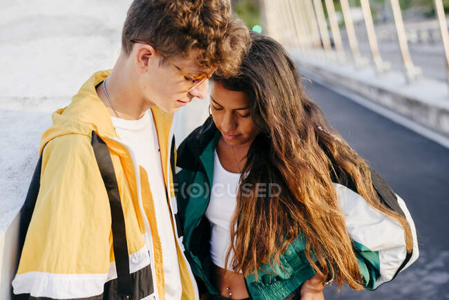 Coupé couple d'adolescents regardant en bas dans la rue — Photo de stock