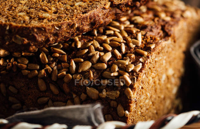 Closeup of tasty cut bread with brown crust and crunchy sunflower seeds on top in wicker basket — Stock Photo