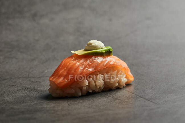 Hoher Winkel des schmackhaften Nigiri-Sushi mit Lachsscheiben auf Reis mit dünnen Scheiben Avocado und Frischkäse — Stockfoto