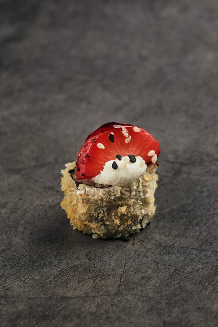 Hoher Winkel der gebratenen japanischen Sushi-Rolle mit Sesam- und Erdbeerscheibe — Stockfoto