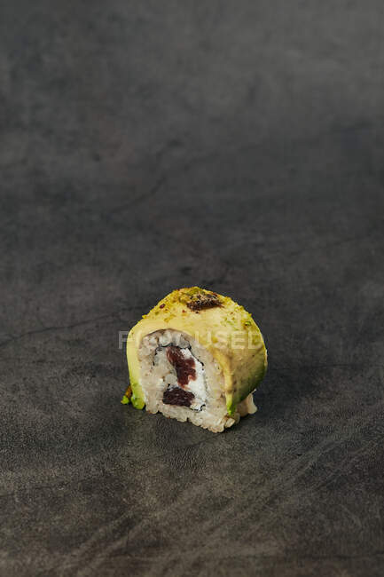 High angle of appetizing traditional Japanese sushi roll with rice avocado cream cheese placed — Stock Photo