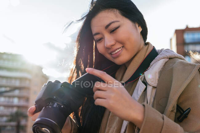 Етнічні молоді щасливі азійські фотографи фотографують на професійній фотокамері на вулицях міста — стокове фото