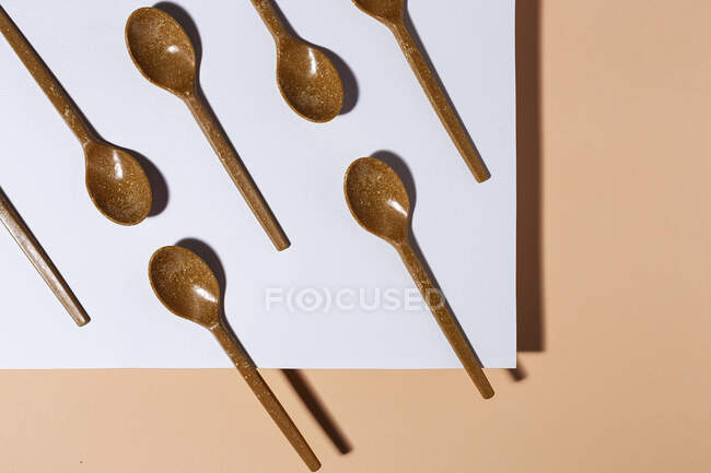 Overhead view of brown eco friendly spoons on pastel background — Stock Photo