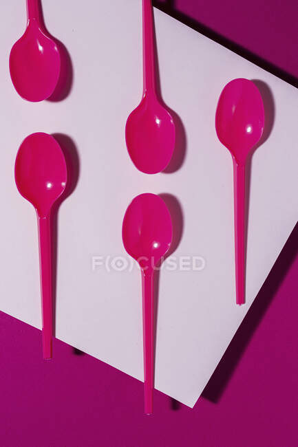 Desde arriba vista de la cuchara ecológica de color rosa brillante sobre fondo de cartón rosa - foto de stock
