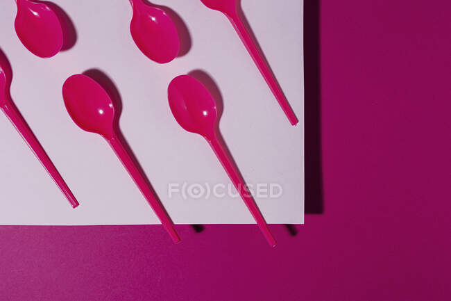 Desde arriba vista de la cuchara ecológica de color rosa brillante sobre fondo de cartón rosa - foto de stock