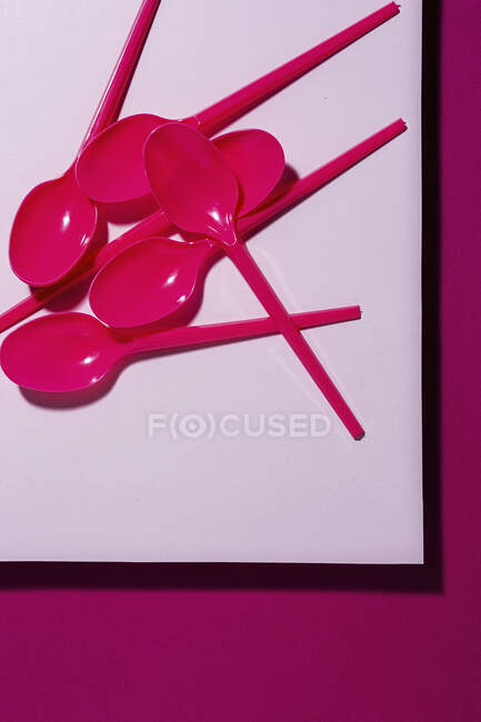 Сверху вид ярко розовой экологически чистой ложки на розовый картонный фон — стоковое фото