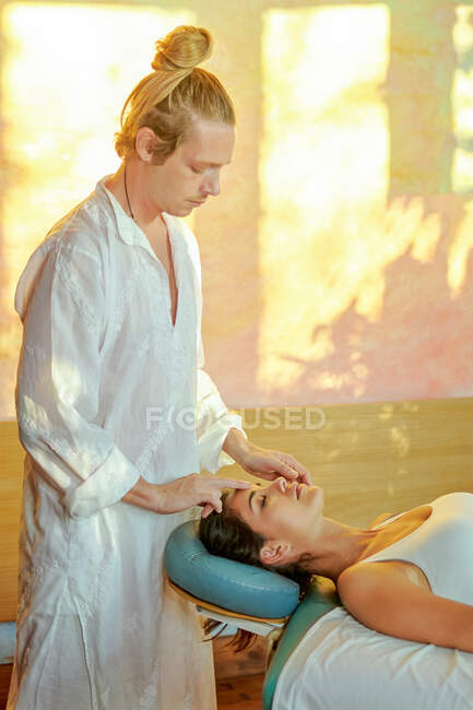 Male practitioner healing female patient with palm technique for recovering soul and body — Stock Photo
