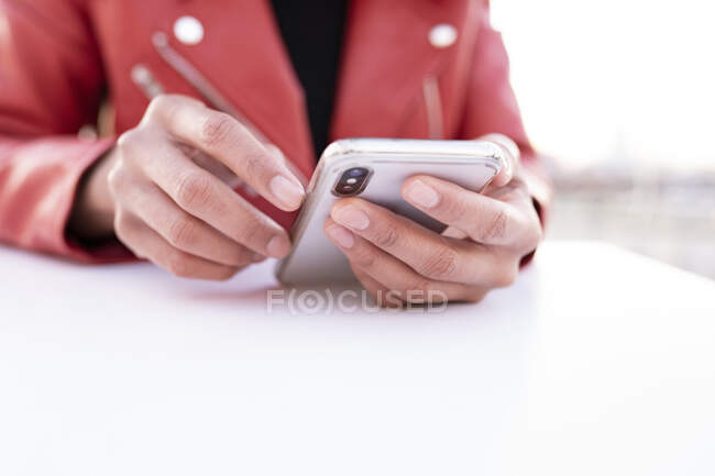 Руки черной женщины с помощью мобильного телефона — стоковое фото