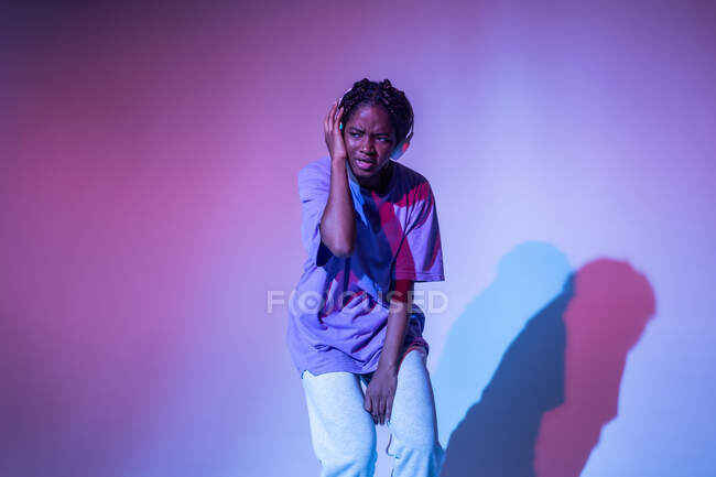 Menina adolescente afro-americana desfrutando de música em fones de ouvido no estúdio de néon — Fotografia de Stock