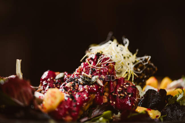 Großaufnahme des Tellers mit leckerem vegetarischem indonesischen Salat mit frischer Mango und Cashewkäsescheiben in der Nähe von Sojabohnen und Gewürzen mit Basilikumvinaigrette — Stockfoto